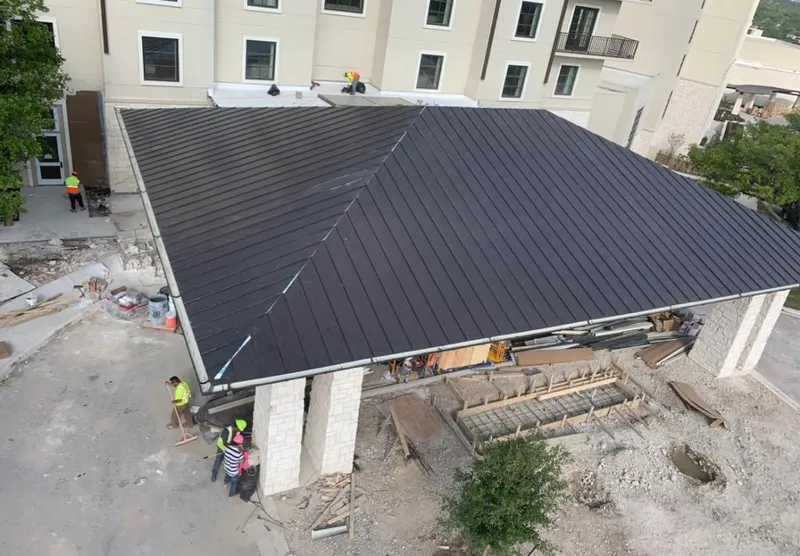 Metal roofing installation team working on a commercial building in Sealy
